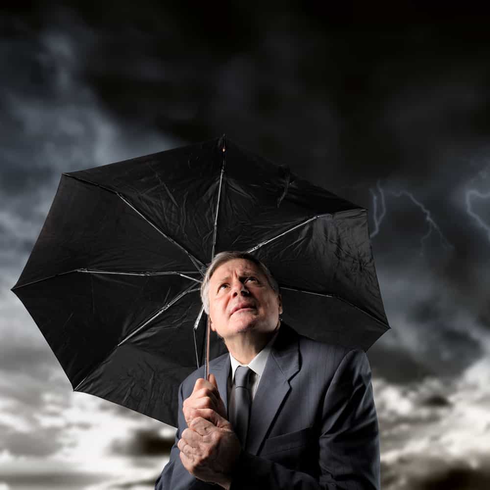 Man holding umbrella in a scary storm